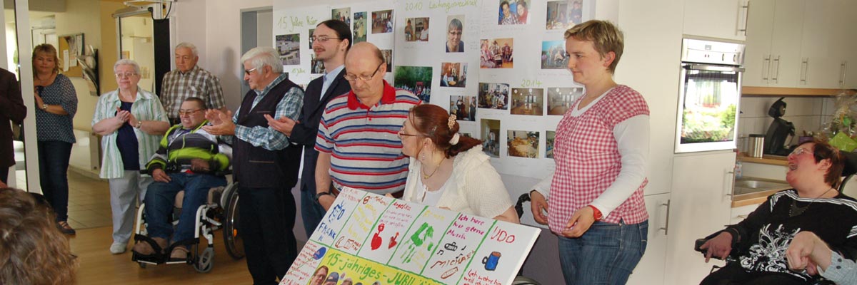 Wohngruppe präsentiert ein Poster zum Jubiläum