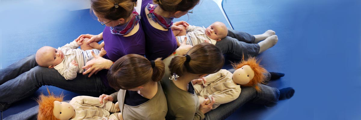 Ein Frau mit Baby, eine zweite Frau mit Stoffpuppe