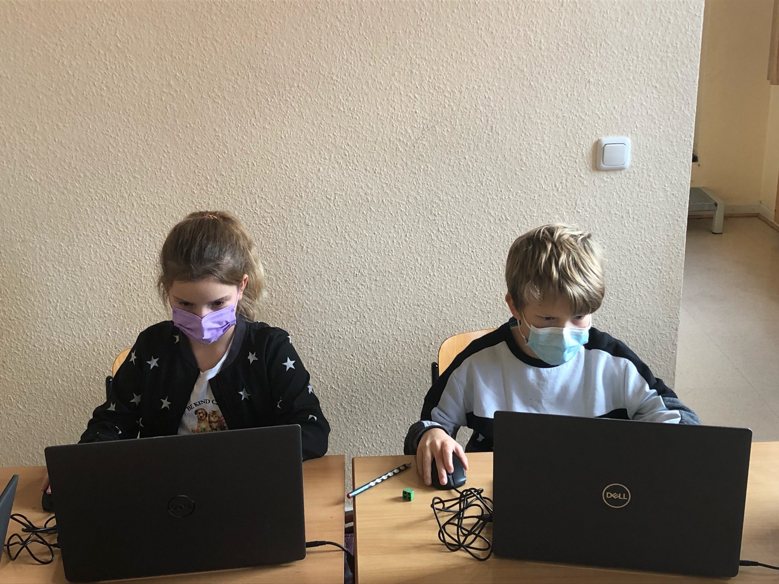 Zwei Kinder sitzen an Laptops