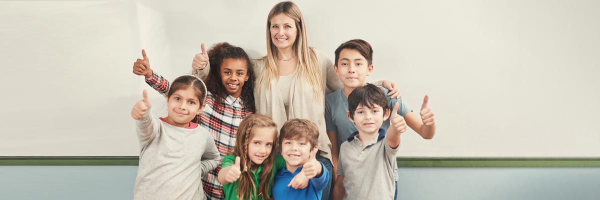 Kinder und ihre Betreuerin machen Zeichen „Daumen Hoch"